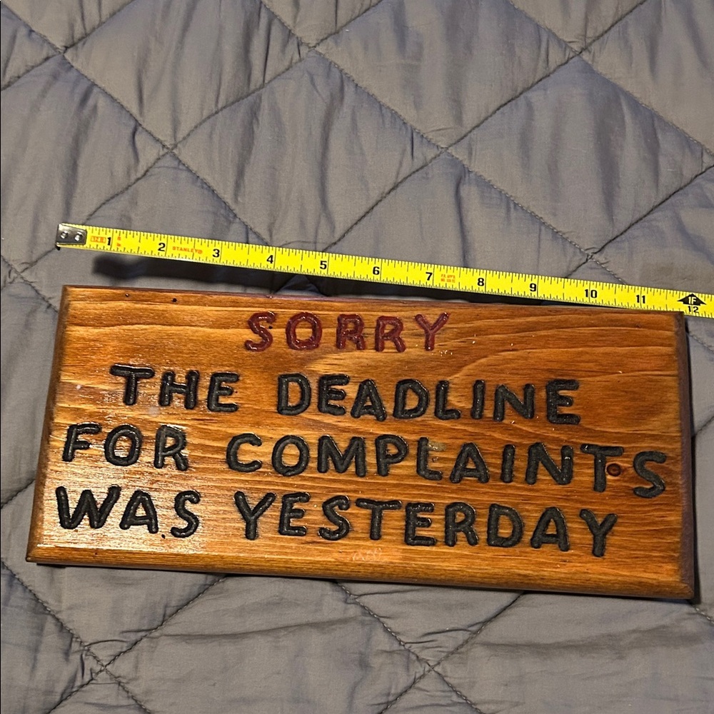 Wooden Sign with Black and Red Text
